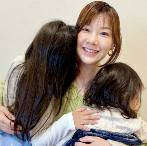 女性社員が女の子2人を抱っこしている写真